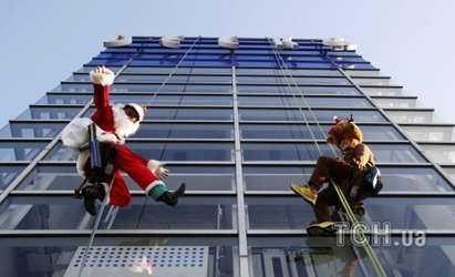 Забавен Дядо Коледа и елени мият прозорците на търговски център в Токио