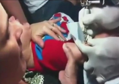 Майка стиска пищящото си дете, докато го татуират! (ВИДЕО)