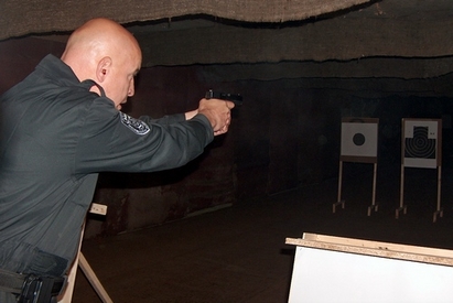 Служители на реда показват точен мерник в турнир по стрелба