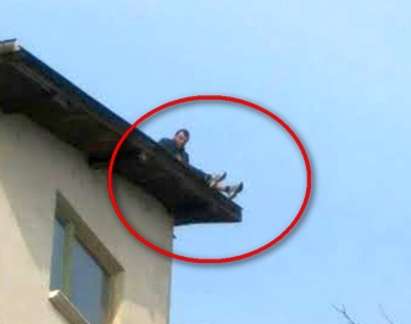 Мъж заплашва да скочи от покривa на триетажната си къща (СНИМКА)