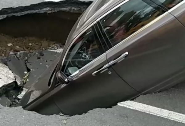 Уникална гледка: Голяма дупка на пътя погълна "Ролс Ройс", шокираният му собственик принуден да спасява живота си (СНИМКИ/ВИДЕО)