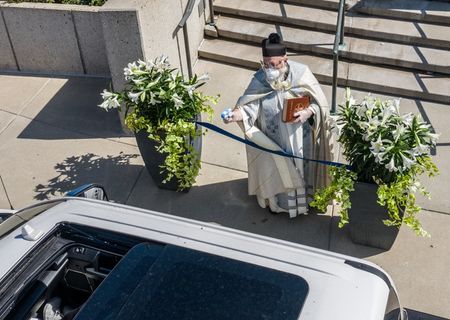 Свещеник пръска светена вода с воден пистолет, за да спази дистанцията (СНИМКИ)