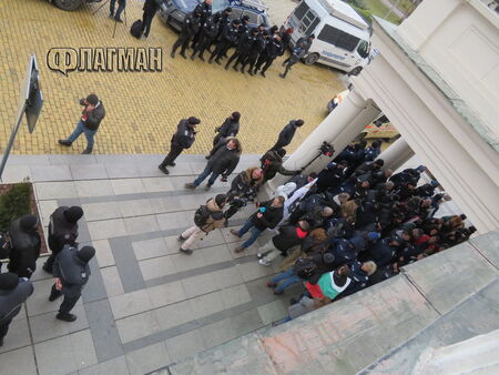 Малка групичка протестиращи проби до един от служебните входове на парламента