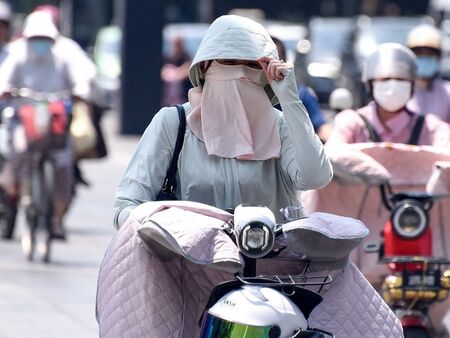 Фейскини - най-новият моден аксесоар в Пекин срещу рекордните жеги