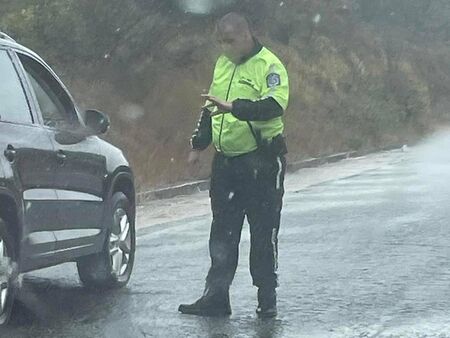 С часове наред този полицай стоя под дъжда, за да помага на блокираните шофьори в Царевско