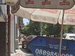 Зад контейнера, поставен на тротоара, се намира автомобил върху тротоара. Спрял като шефа на улицата